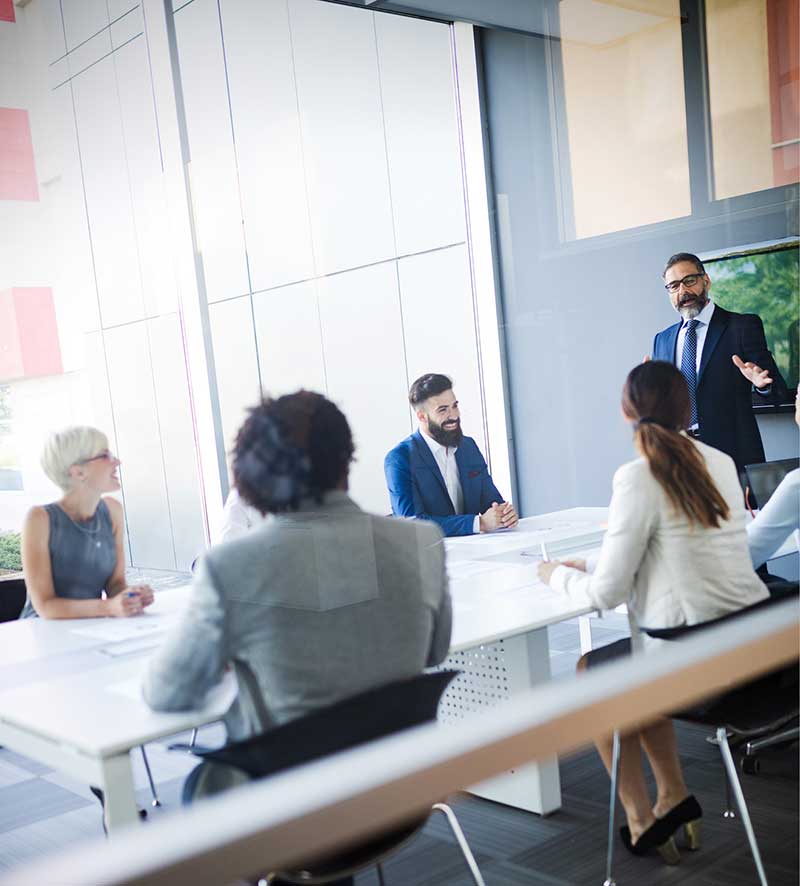 Foresee Now specialist in blue suit leads group discussion around office conference table