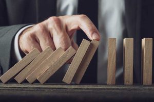 Foresee Now specialist catches domino from falling to represent how crisis prevention works