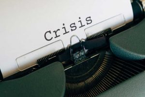 Green typewriter displays crisis response on white paper
