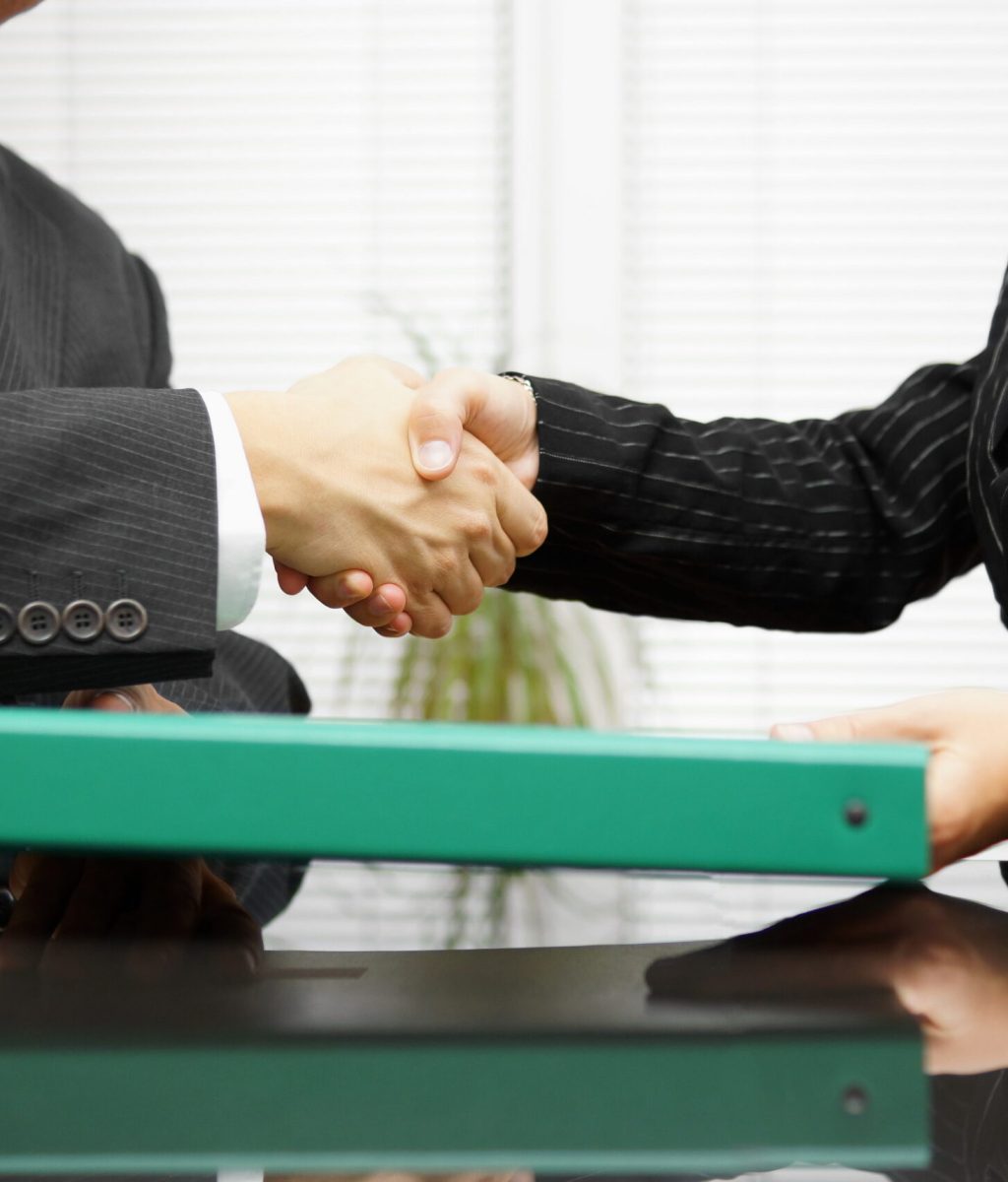 businessman is passing binder with documentation to his client businessman is passing binder with documentation to his client while handshaking
